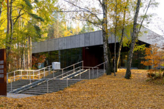 wejście do muzeum, schody, ziemia pokryta liśćmi, wokół las