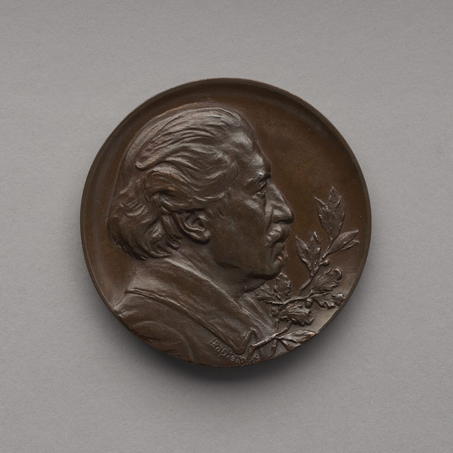 Zdjęcie medalu. Na medalu płaskorzeźbione popiersie mężczyzny z profilu.