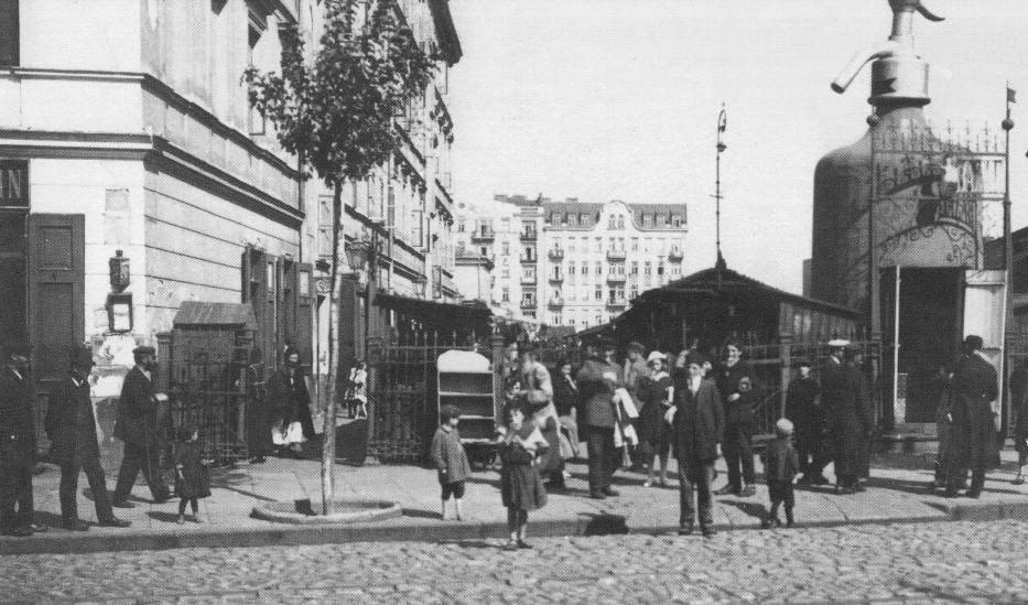 Fotografia czarno-biała. Ludzi przed bazarem Różyckiego.