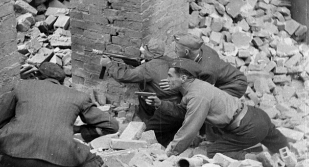 Zdjęcie: Wanda Traczyk z „Błyskawicą” (w środku, w pilotce ukrywającej bandaż), fragment inscenizowanego materiału filmowego nakręconego we wrześniu 1944 roku, kadr z dokumentalnego filmu "Portret Żołnierza", reż. Marianna Bukowski